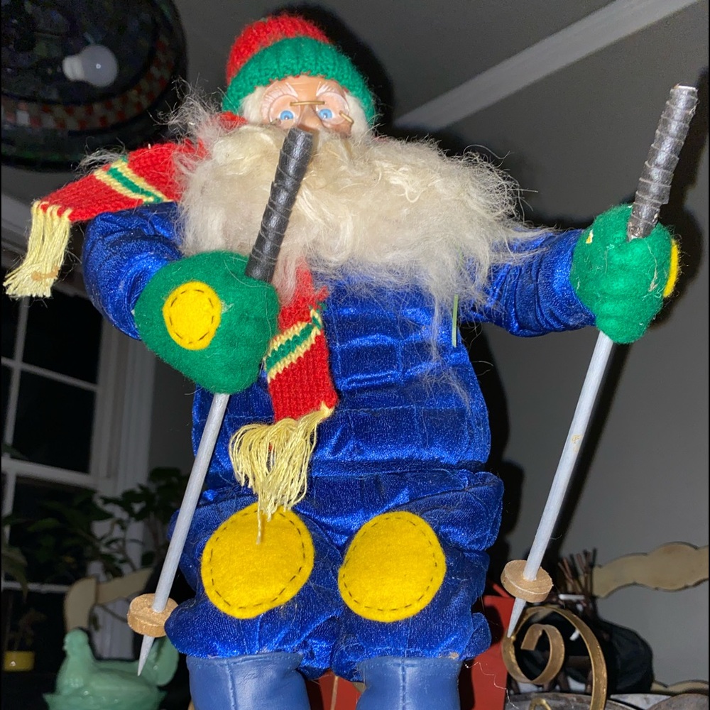 Skiing Santa plush doll like statue on wooden base.